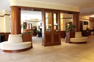 a lobby with two white chairs in a hotel at Hotel Valentino in Acqui Terme