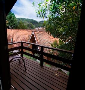 a bench sitting on top of a wooden deck at Pousada Sol Nascente in Monte Verde