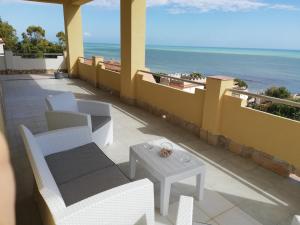 a balcony with a table and chairs and the ocean at Villa Fiorella in Sciacca
