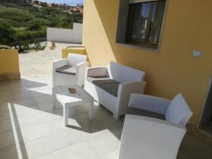 a group of white chairs and tables on a patio at Villa Fiorella in Sciacca