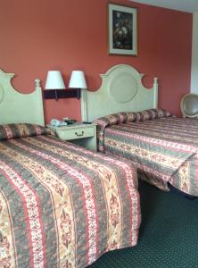 two beds in a hotel room with red walls at New Orleans Inn in New Orleans