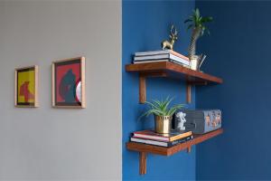 uma prateleira com livros e uma planta na parede em Monet Tower By The Local Way em Cidade do México