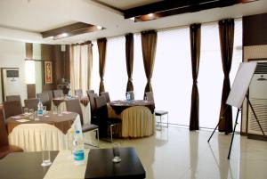 a conference room with tables and chairs and windows at Hotel Orbit in Chandīgarh