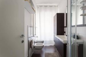 een witte badkamer met een toilet en een wastafel bij Delizioso bilocale in Bocconi - Porta Romana in Milaan