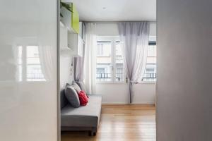 a living room with a couch and a window at Delizioso bilocale in Bocconi - Porta Romana in Milan