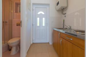 a bathroom with a toilet and a sink and a door at Apartmani Mirta in Dramalj +54 photos