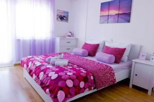 um quarto com uma cama rosa e branca com almofadas cor-de-rosa em Villa Barbara em Split
