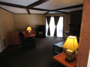 a living room with a couch and a table and a lamp at The Lake George Inn in Lake George