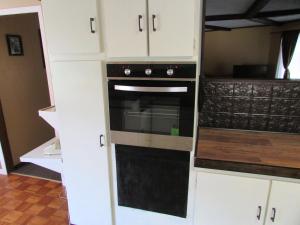 a kitchen with a black oven and white cabinets at The Lake George Inn in Lake George