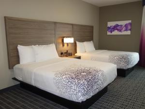 ein Hotelzimmer mit 2 Betten mit weißer Bettwäsche in der Unterkunft La Quinta by Wyndham San Antonio Alamo City in San Antonio