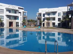 a swimming pool in front of two apartment buildings at Très haut standing piscine, plage + Netflix in Agadir