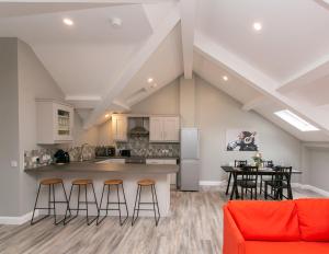 an open kitchen and dining area with stools at University Road Apartments in Belfast