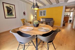 - une salle à manger avec une table et des chaises en bois dans l'établissement LE PTIT BARTHO, à Colmar