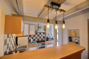 - une cuisine avec un comptoir en bois dans l'établissement LE PTIT BARTHO, à Colmar