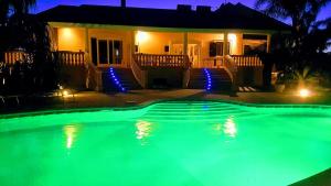 a swimming pool in front of a house at night at villa Bismarkia in Siracusa
