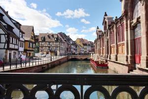 a river in a city with buildings and a bridge at LE PTIT BARTHO in Colmar +3 photos