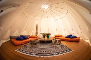 Ca Stella Camping del Monte San Giorgio في Meride: غرفة بها كنبتين وطاولة في خيمة