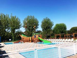 una piscina con scivolo e un parco giochi di New Campsite in Camping Ca' Savio a Cavallino-Treporti