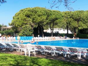 a swimming pool with chairs and people in the water at New Campsite in Camping Ca' Savio in Cavallino-Treporti