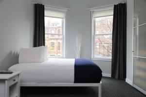 a bedroom with a bed and two windows at Stylish Newbury Street Studio, #4 in Boston