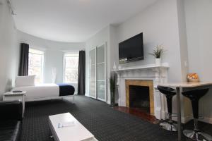 uma sala de estar com uma cama e uma lareira em Stylish Newbury Street Studio, #4 em Boston