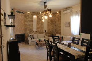 uma sala de estar com um sofá e uma mesa com cadeiras em Stone Apartment em Tessalônica