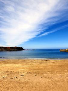 a sandy beach with a view of the ocean at The Herring Queen in Eyemouth