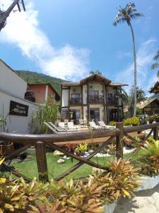 una casa con una valla de madera delante de ella en Pousada Caiçara en Ilha Grande