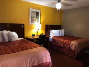 a hotel room with two beds and a desk with a lamp at Ellijay Inn - Downtown Ellijay in Ellijay