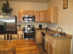 a kitchen with wooden cabinets and a stainless steel refrigerator at Mountain Man Cabin in Wapiti