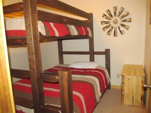 a bedroom with two bunk beds and a clock at Mountain Man Cabin in Wapiti