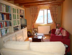 a living room with two white couches and a window at La Charlisa in Pra-Loup