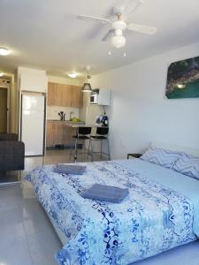 a bedroom with a blue bed and a kitchen at Paradise Candelaria in Candelaria