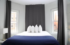 a bedroom with a blue and white bed with windows at Stylish Studio on Newbury Street, #10 in Boston