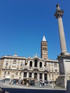 un gran edificio con una torre de reloj y una columna en Happy Stay Guesthouse en Roma