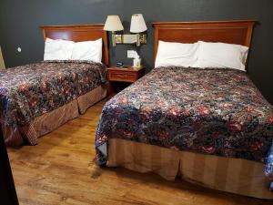 a hotel room with two beds and two lamps at Pacific Motel in Gridley