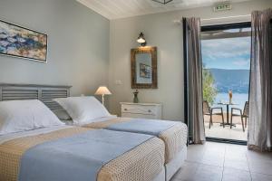 2 letti in una camera da letto con vista sull'oceano di Martini Waterfront Suites a Fiskardho