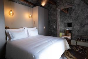 a bedroom with a large white bed in a room at Vila Foz Hotel & SPA - member of Design Hotels in Porto