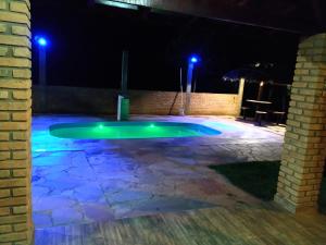 una piscina por la noche con luces azules en Recanto Shambala, en São Thomé das Letras