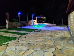 a backyard pool at night with a gazebo at Recanto Shambala in São Thomé das Letras