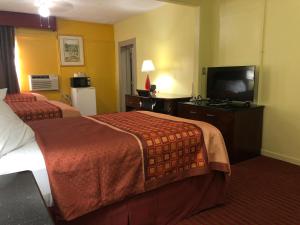 a hotel room with two beds and a flat screen tv at Ellijay Inn - Downtown Ellijay in Ellijay
