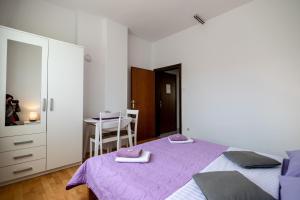 a bedroom with a purple bed and a table at Room Anton in Rakovica