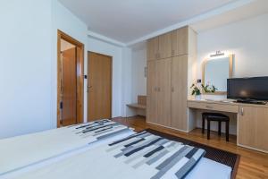 Schlafzimmer mit einem Bett, einem Schreibtisch und einem TV in der Unterkunft Apartments and Room Robert in Korenica