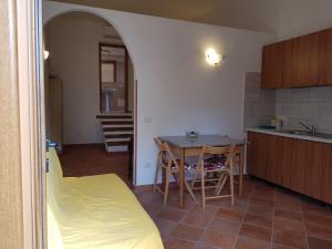 a kitchen with a table and a dining room at stupenda casetta in centro storico in La Maddalena