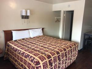 a bedroom with a bed with a bedspread on it at Mount-N-Lake Motel in Wofford Heights