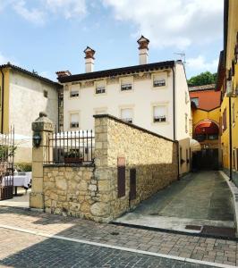 a large white building with a stone wall at Locanda Lo Scudo in Soave