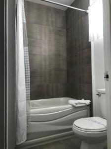 ein Bad mit einer Badewanne und einem WC in der Unterkunft Complexe Dix80 in Mont-Laurier