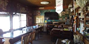 a dining room with tables and chairs and a television at Guest House Shiraishi in Kasaoka