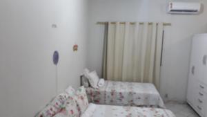 a small bedroom with two beds and a radiator at Home Sweet Home Flats in Brasilia