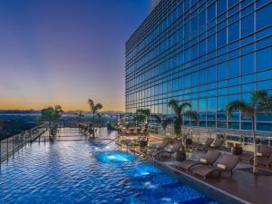 un hotel con piscina con sillas y un edificio en Richmonde Hotel Iloilo, en Iloilo City